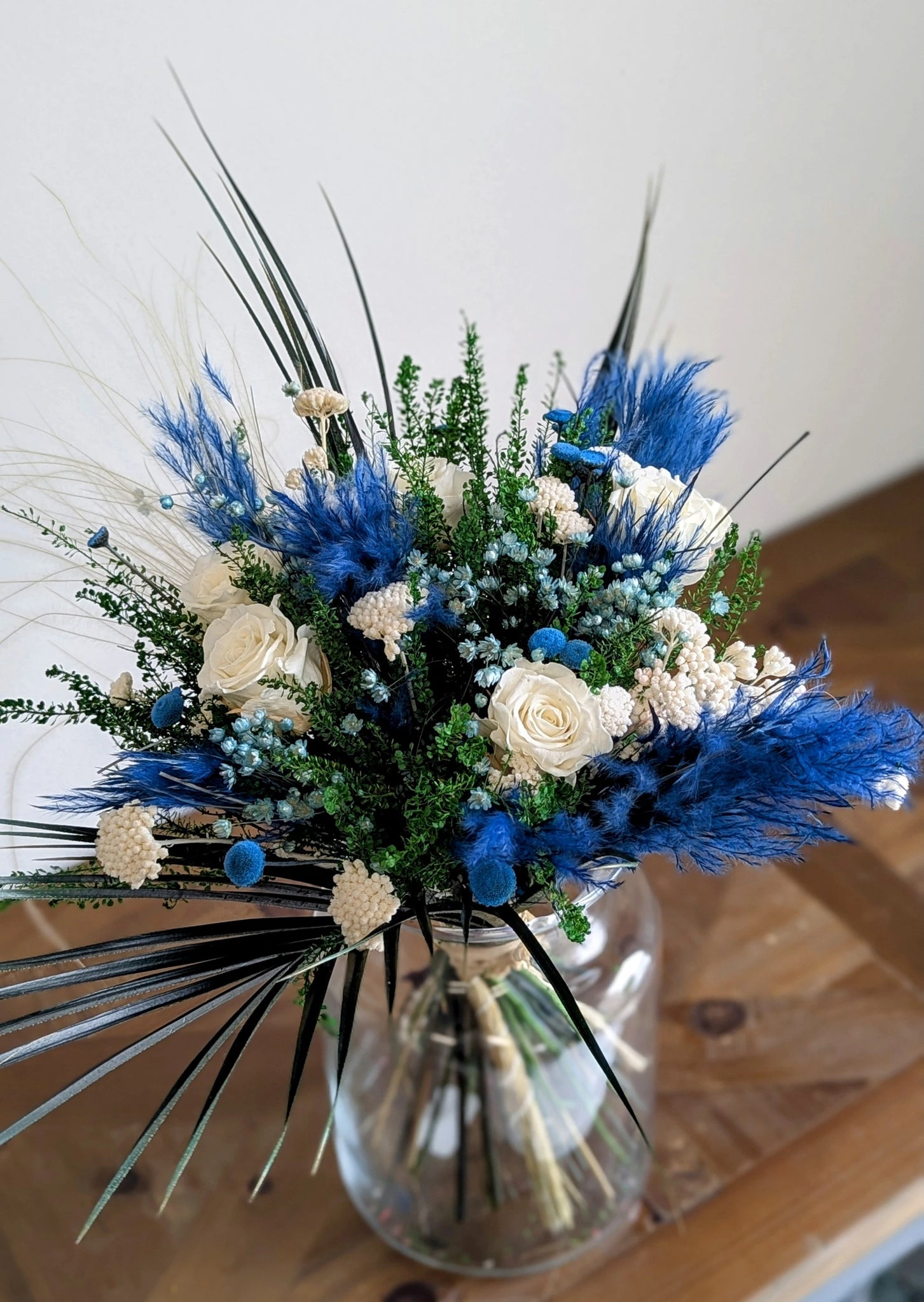 
Composition florale artisanale aux tons bleus et blancs sur fond neutre