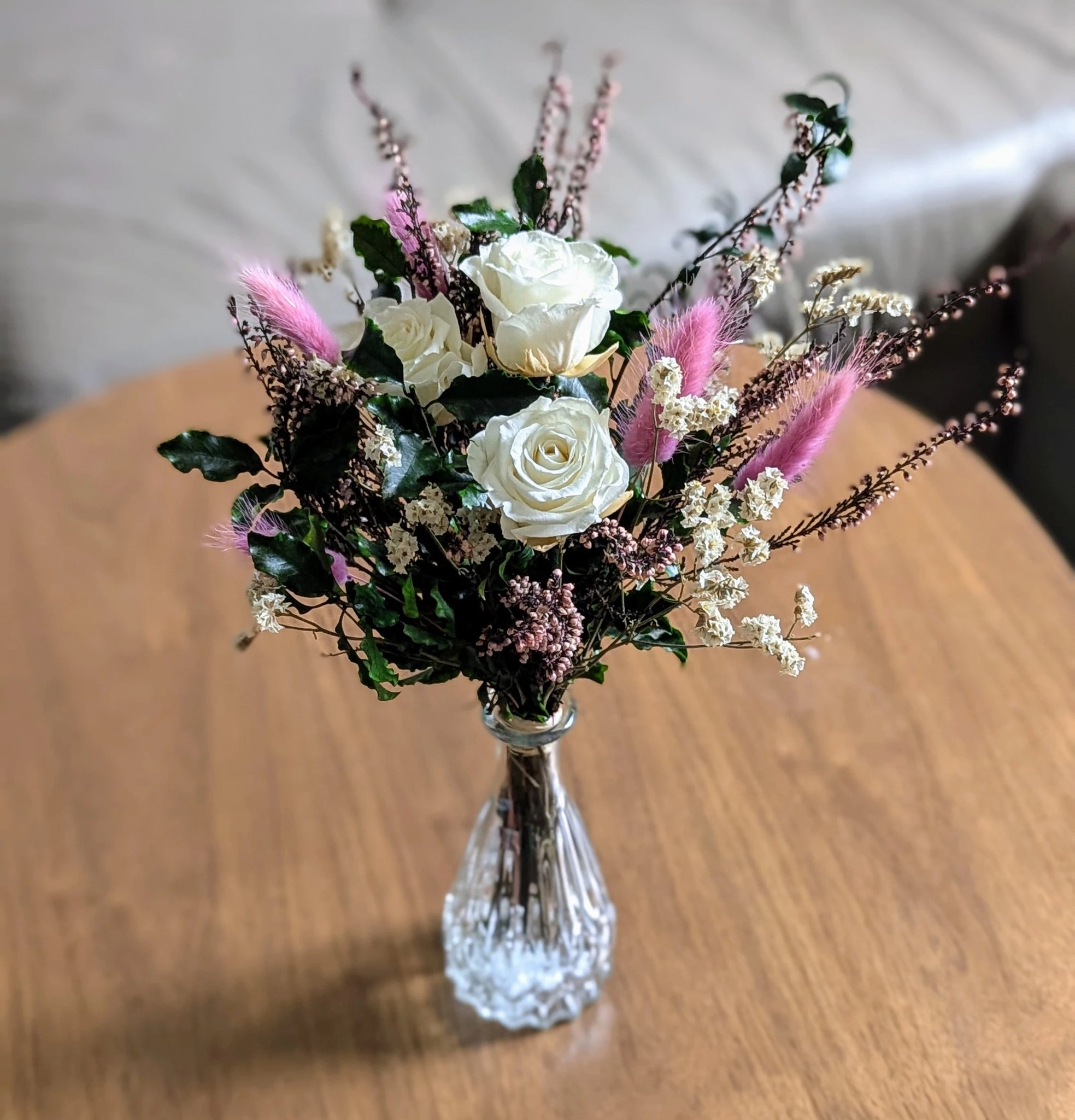 Bouquet MANON avec roses ivoires et feuillage blanc dans un vase texturé.