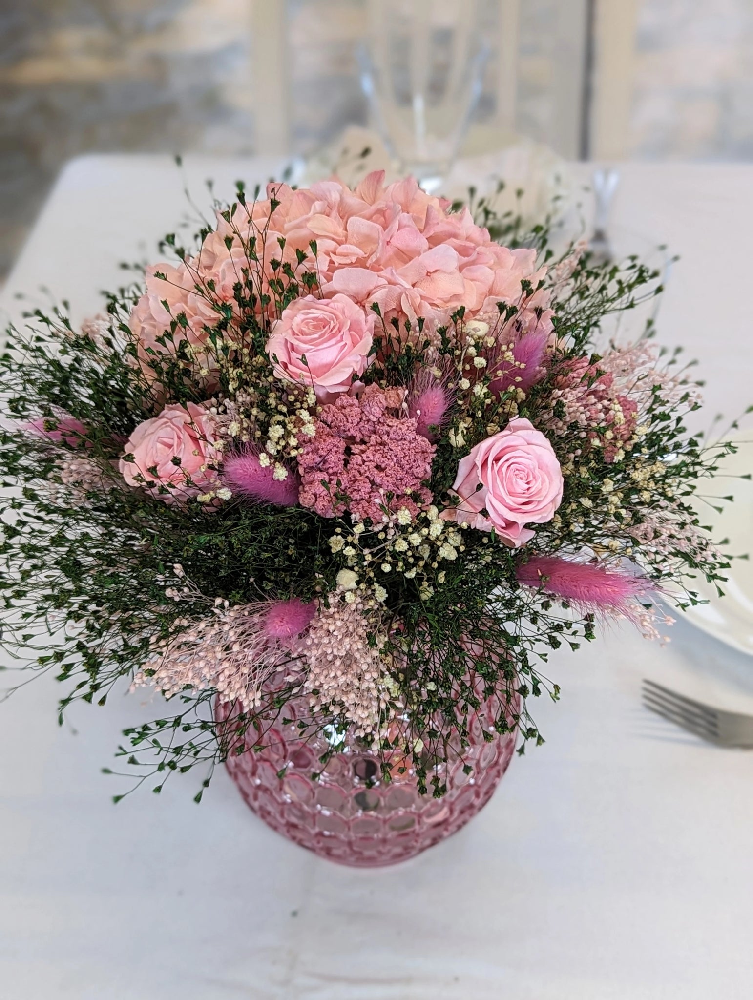 gros bouquet avec fleurs rose mise en situation sur table blanche vase rose