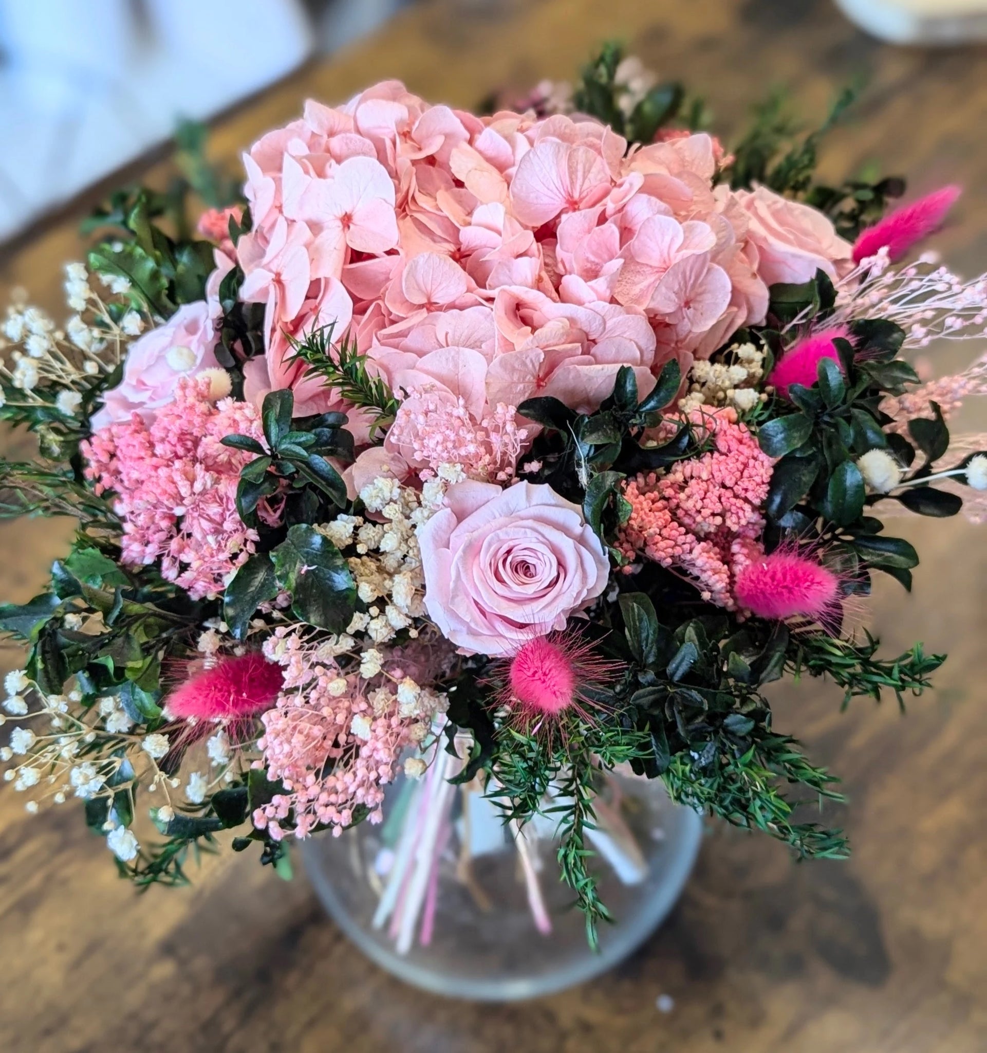 gros bouquet avec fleurs rose mise en situation sur table blanche vase transparent