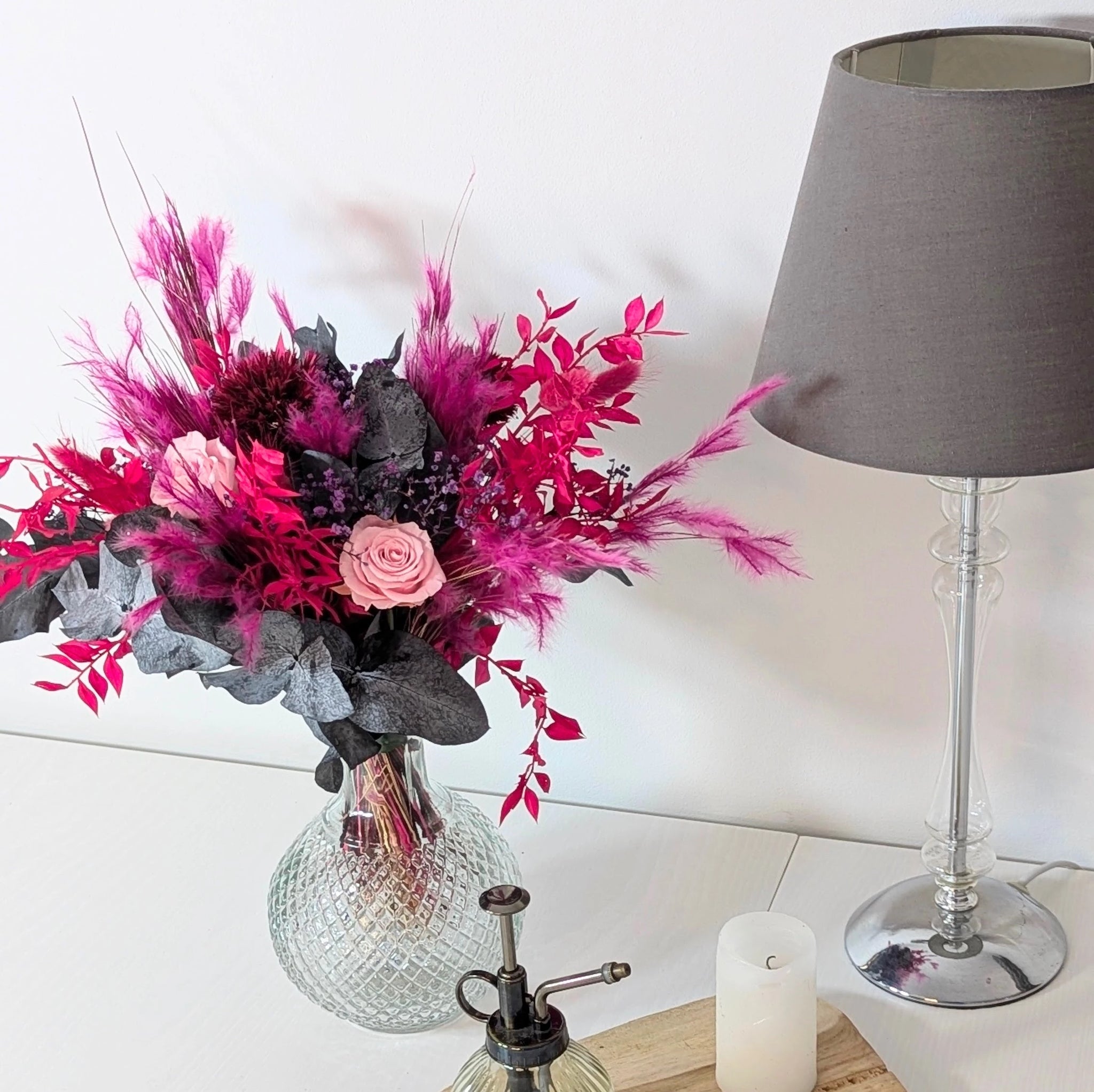 beau bouquet rose et fuchsia dans vase transparent sur table blanche