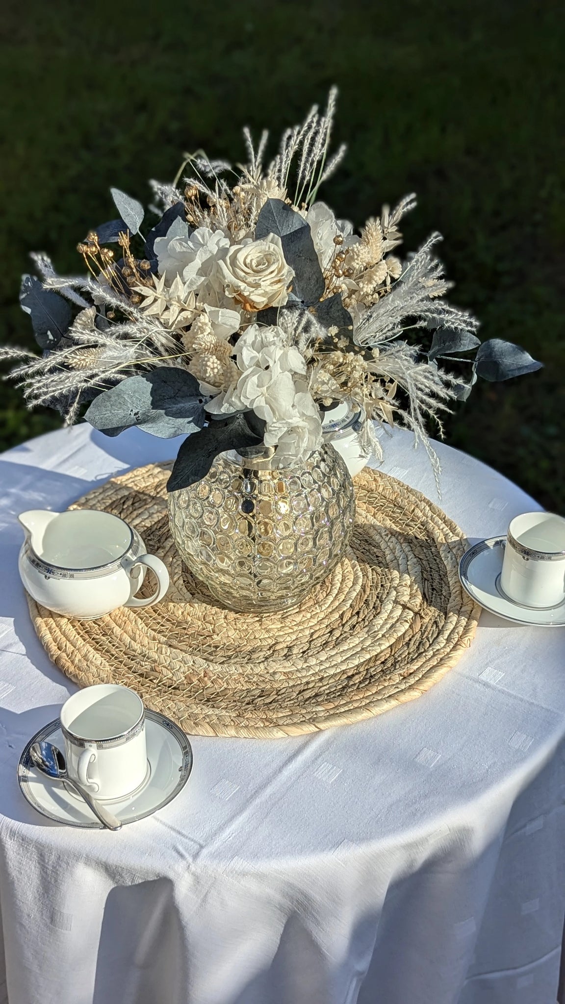 Gros Bouquet blanc, eucalyptus et gypsophile mis en situation en extérieur sur jute naturelle