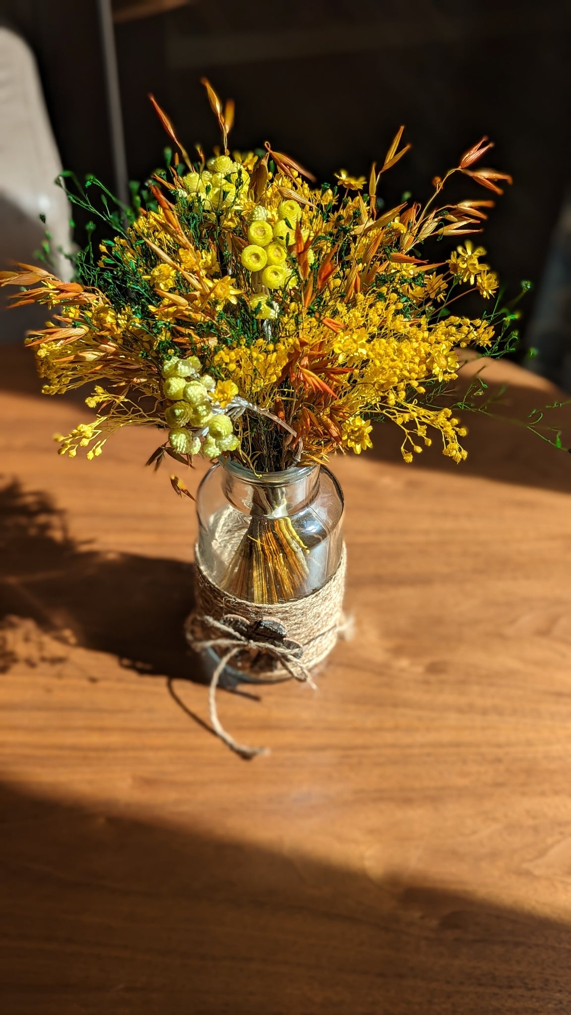 Bouquet fleurs jaunes et oranges dans petit vase en verre
