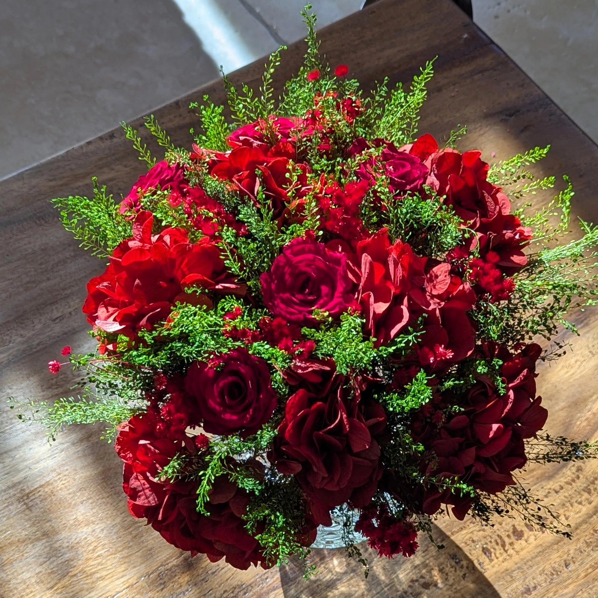 Bouquet décoratif en fleurs stabilisées rouges, élégant et durable.