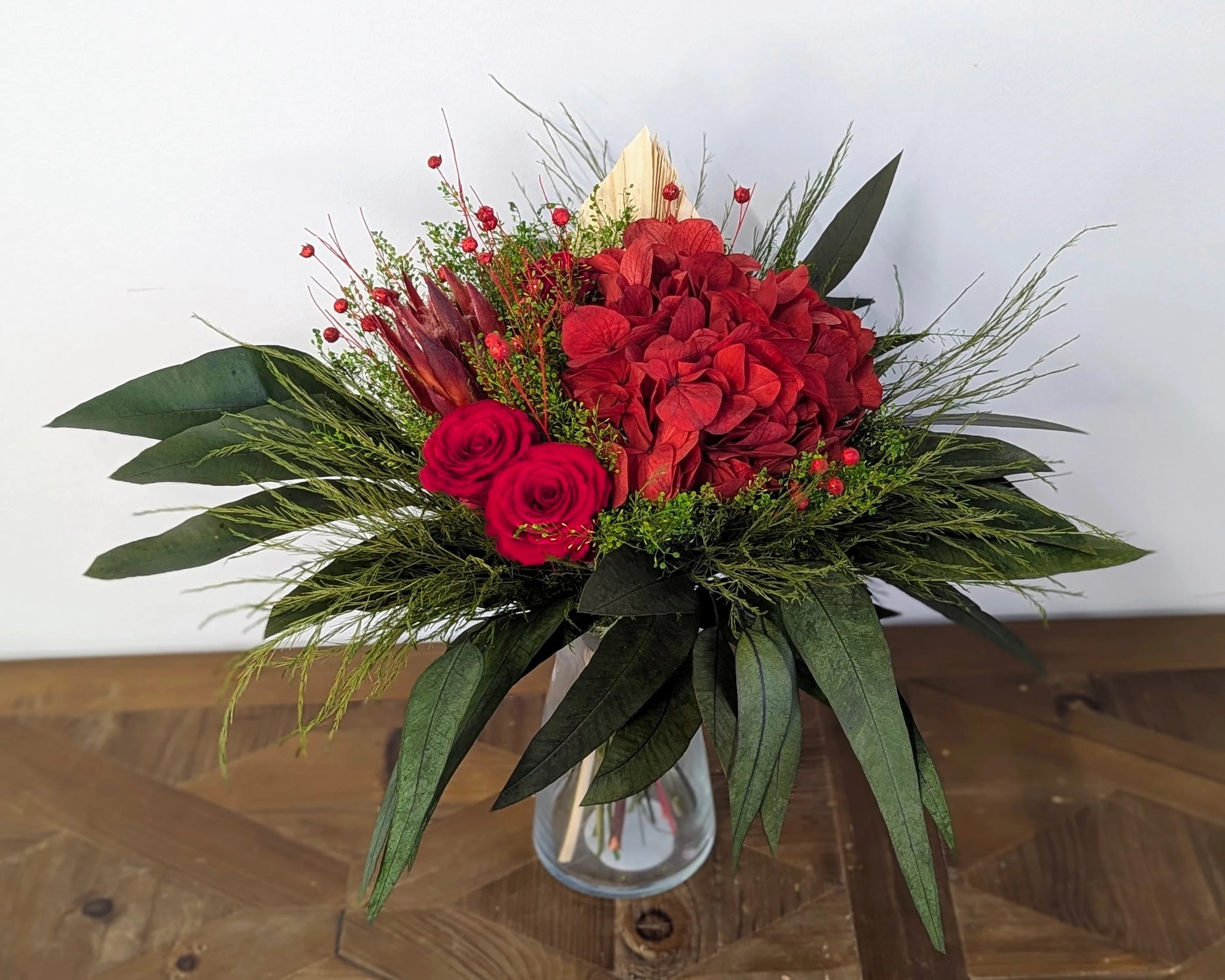 Un éclat de passion capturé dans un bouquet. Rouge profond, feuillage élégant et textures contrastées : chaque fleur est éternelle, chaque émotion reste vivante.

