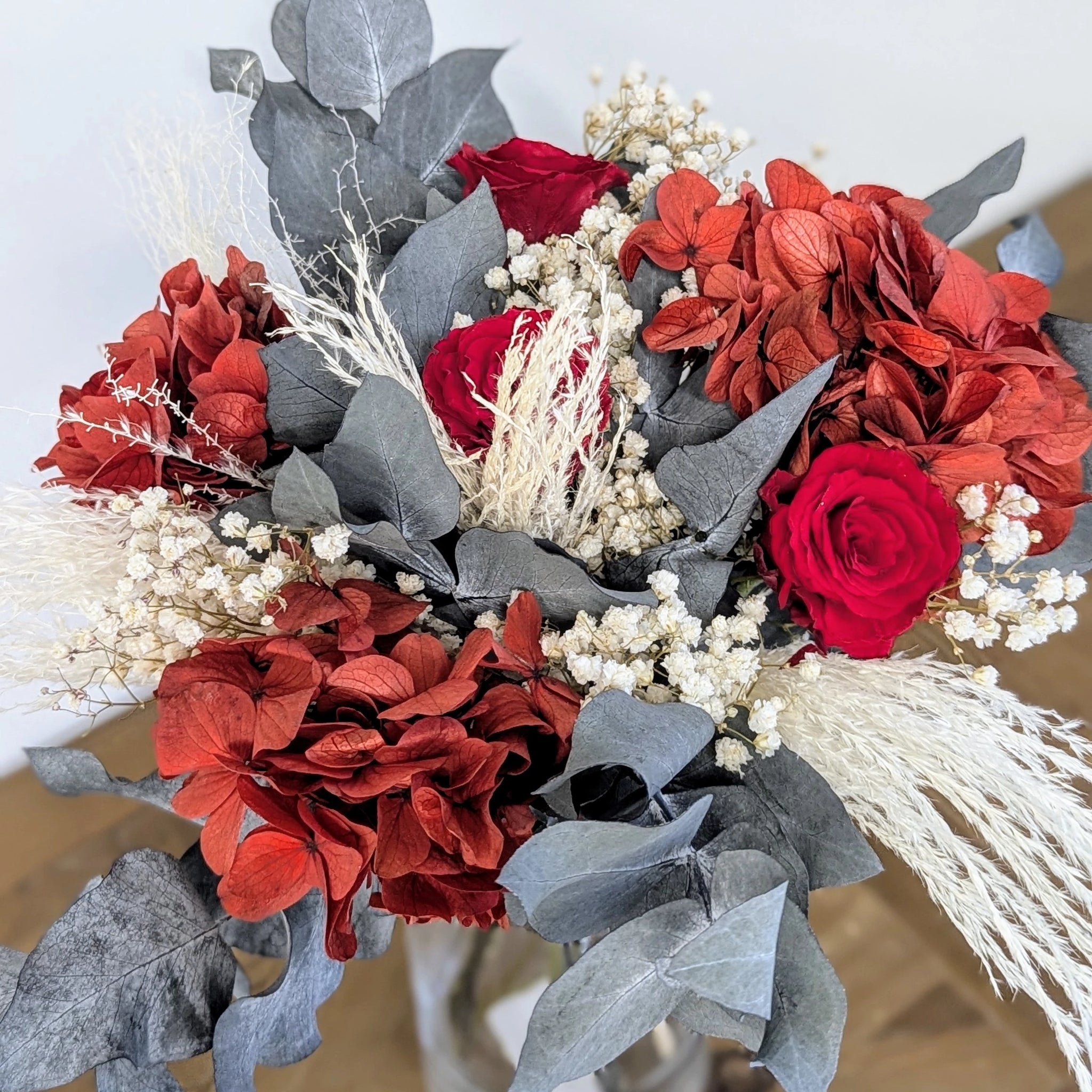 Bouquet chic et durable : roses rouges, hortensias et eucalyptus.