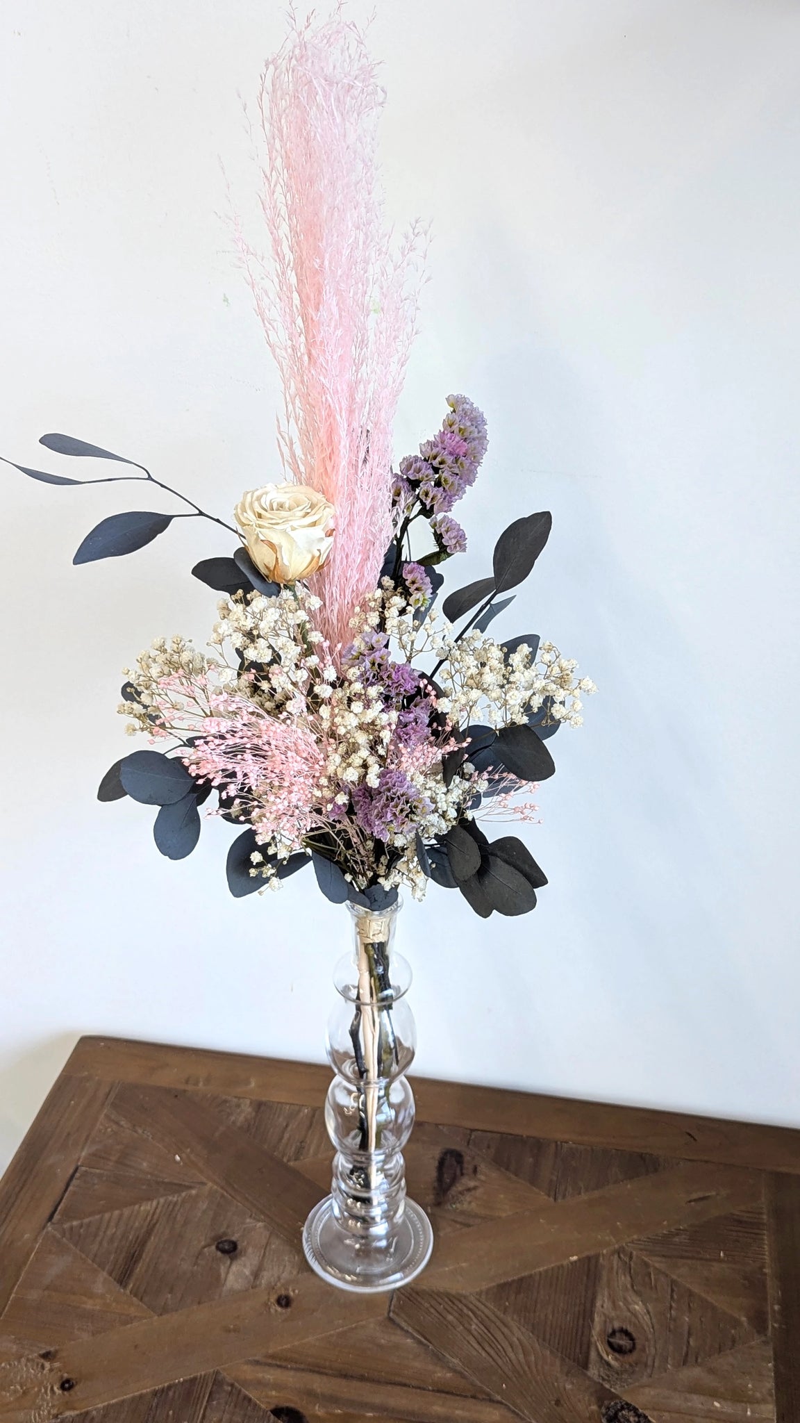 Bouquet et vase haut avec fleurs stabilisées pour une décoration élégante.