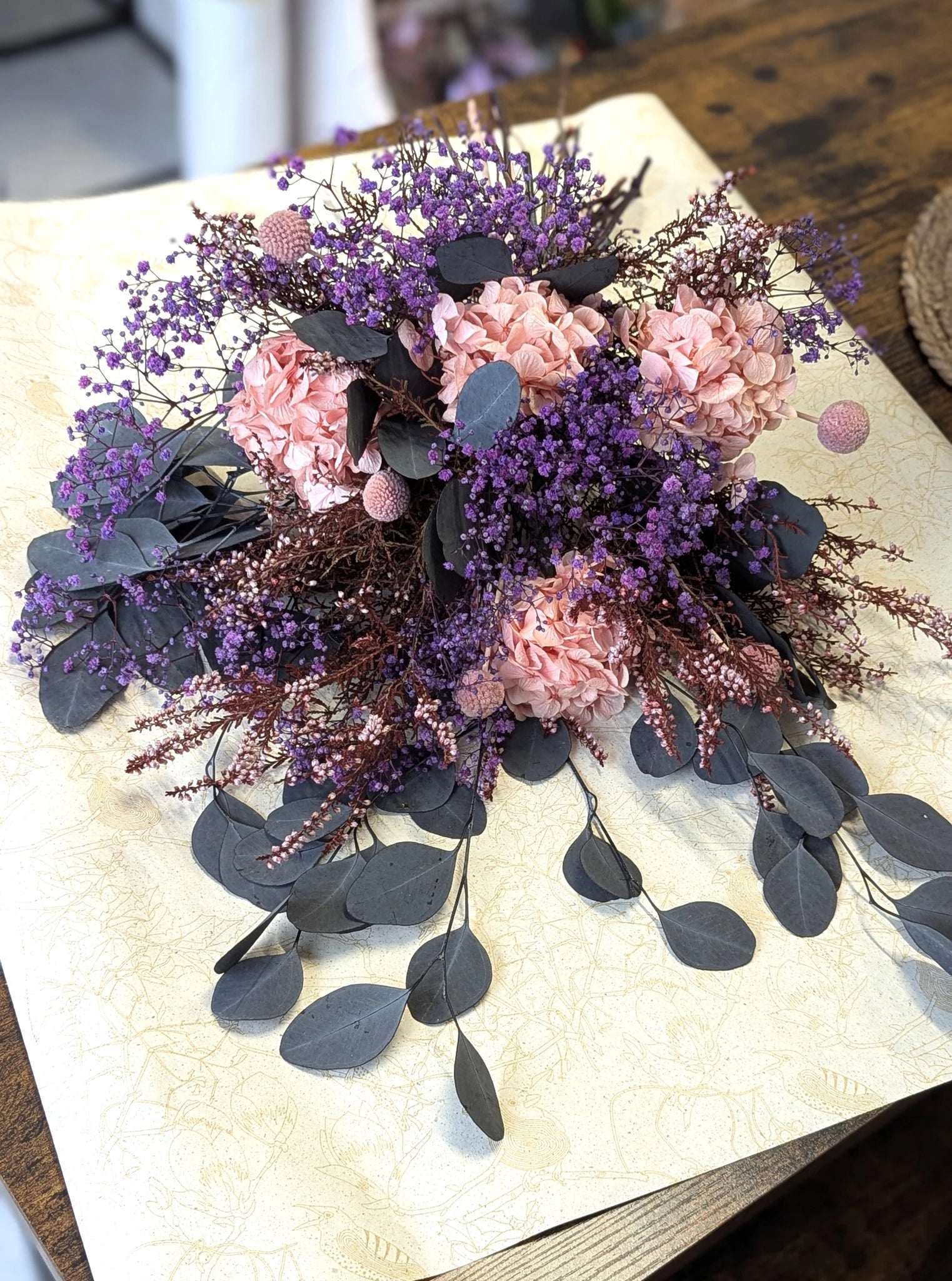 Gerbe de fleurs stabilisées – Hommage naturel et durable
Offrez un hommage poétique avec cette gerbe de fleurs stabilisées dans des teintes de violet et de rose, complétée par de l'eucalyptus et des fleurs séchées. Spécialement conçue pour l'extérieur, elle conserve sa beauté pendant environ un mois, offrant un témoignage durable de vos pensées. Cette création allie élégance, simplicité et respect de la nature.