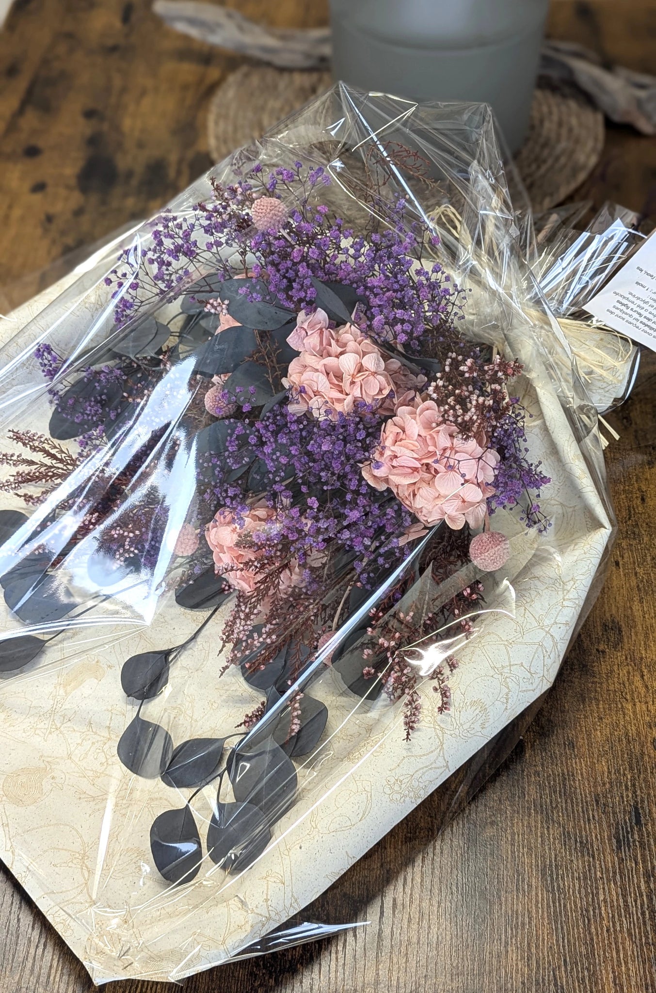 Gerbe extérieure en fleurs stabilisées – Élégance et respect
Exprimez vos pensées avec cette gerbe raffinée composée d'hortensias roses, de violette gypsophile et de branches d'eucalyptus stabilisées. Idéale pour l'extérieur, elle reste éclatante pendant un mois environnant, même exposée aux éléments. Une alternative écologique et poétique aux bouquets frais pour des hommages marquants.