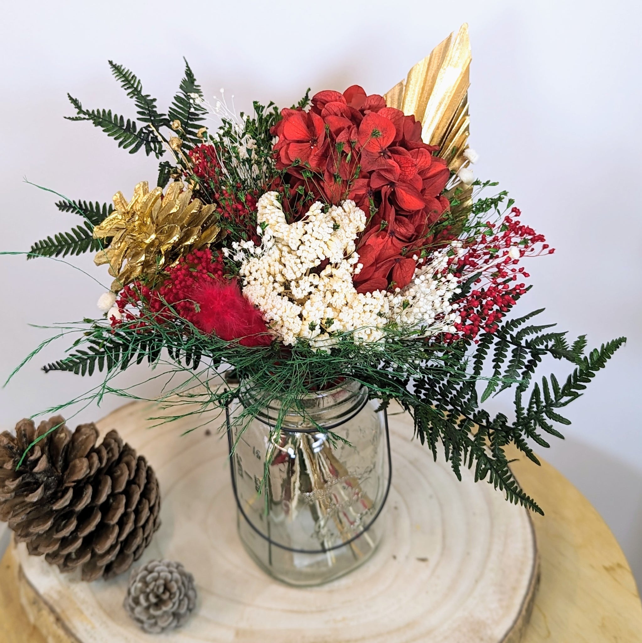 bouquet fleurs rouges, plume rouge, fleurs beiges, feuilles et pigne de pin dorées 