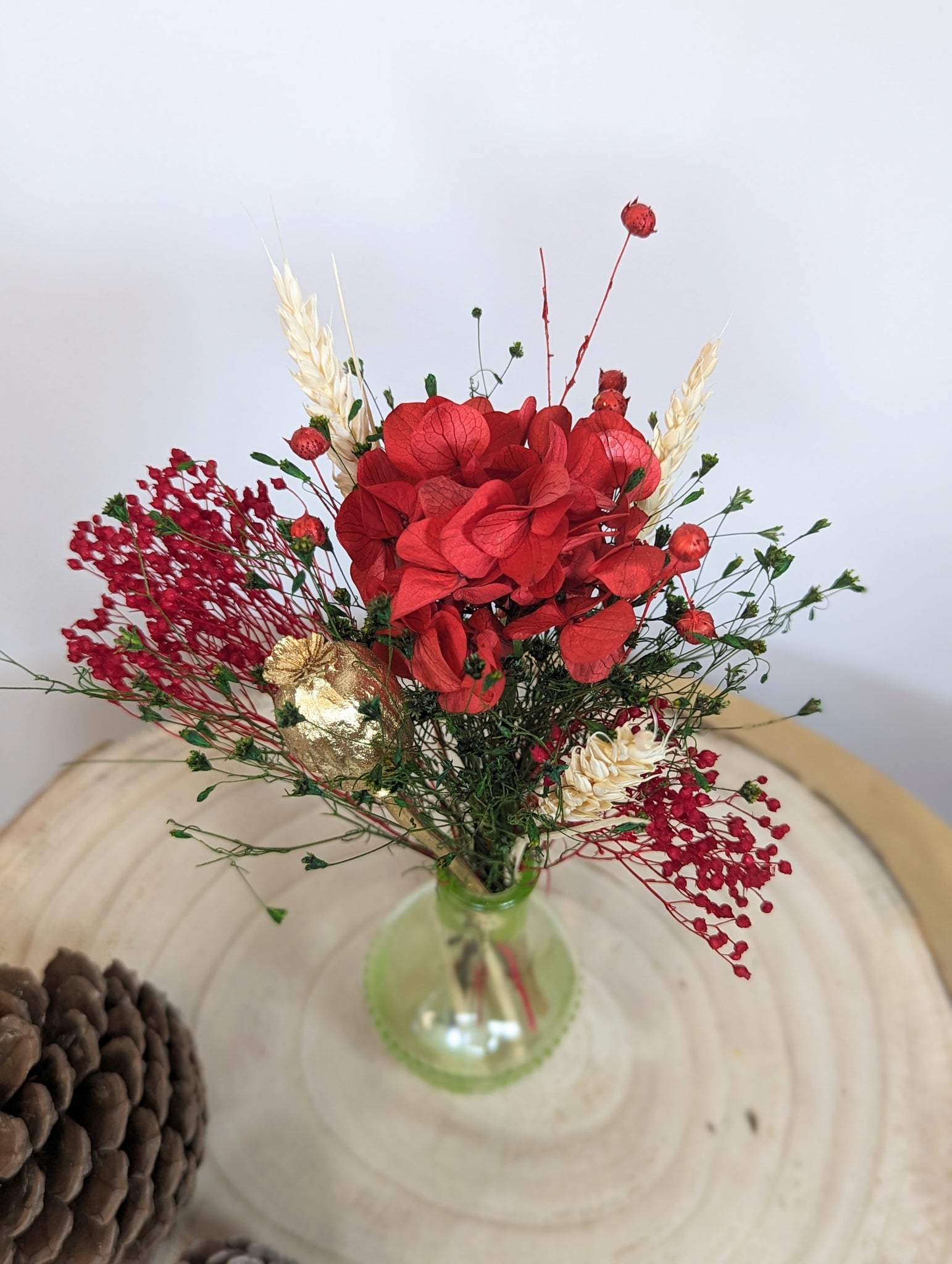 composition de fleurs rouges et fleurs séchées plateau bois vu dessus